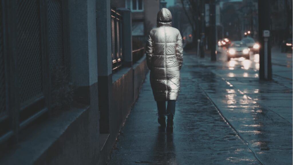 Person in raincoat walking alone in the city