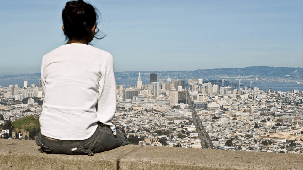 Woman overlooking the city for digital nomad in astrocartography